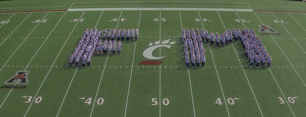 Facilities Management staff in the shape of the letters FM on Nippert Stadium field