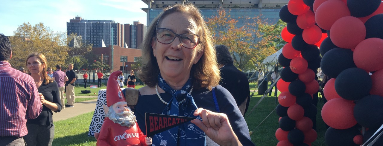 A UC professor shows off a Cincinnati-themed gnome at UC's homecoming celebrations.