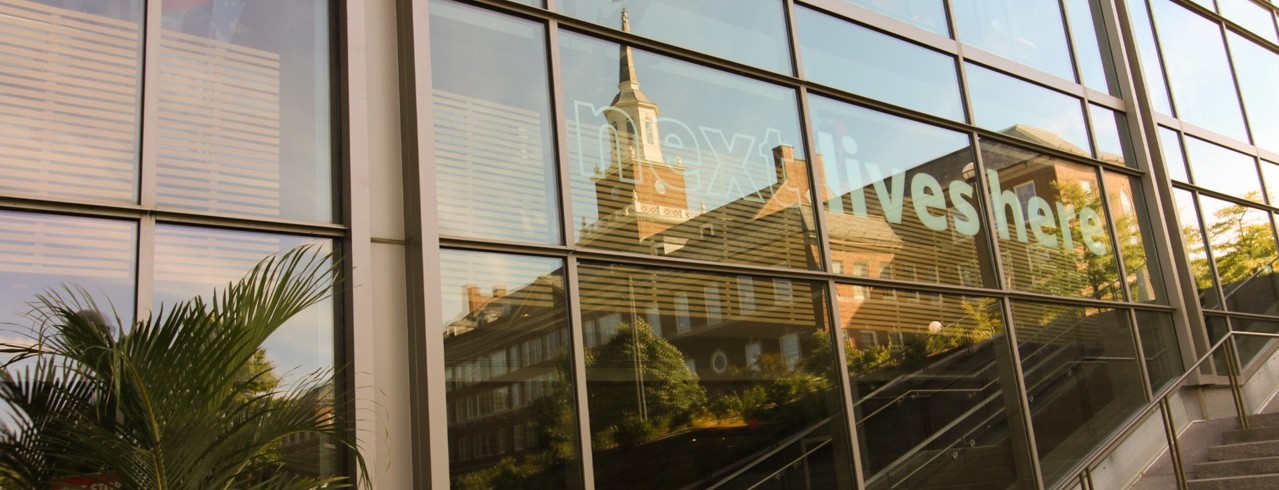McMicken Hall reflected in the windows of University Pavilion.