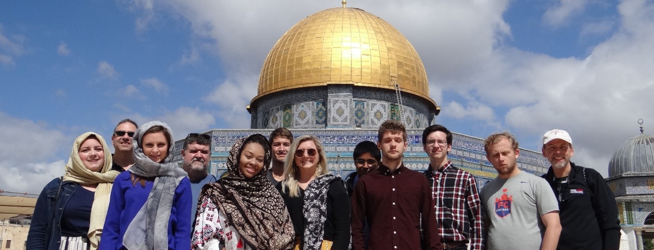 Students stand in front of a gold-domed mosque in Tel Aviv, Israel.