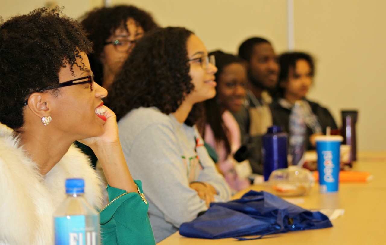 Black students smiling at the Black Feminist Symposium. 
