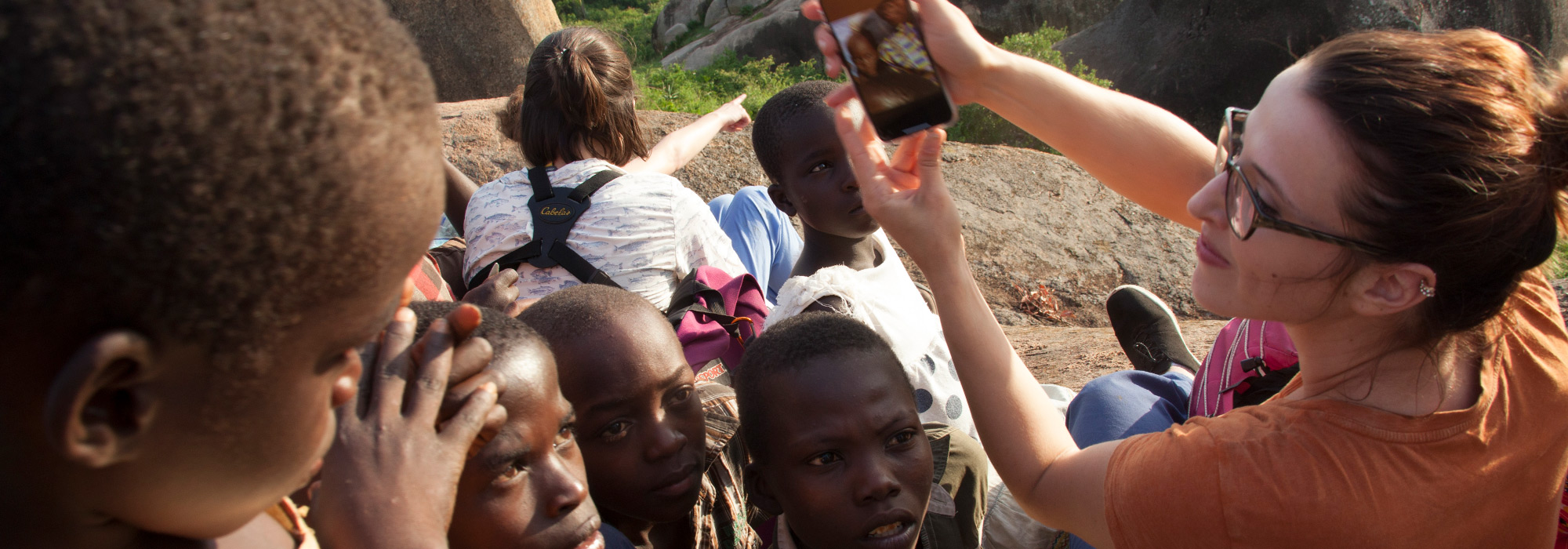 Pharmacy student Lauren Stacey shares photos with local children on a hike in Tanzania