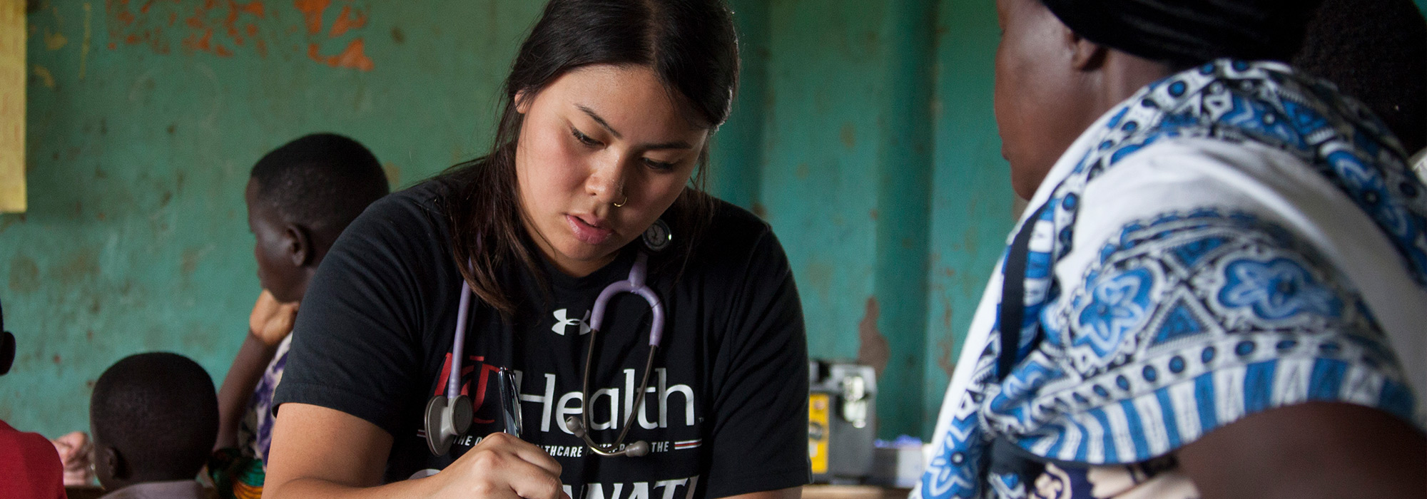 Nursing student Sabrina Bernardo helps a patient in a free clinic in Tanzania