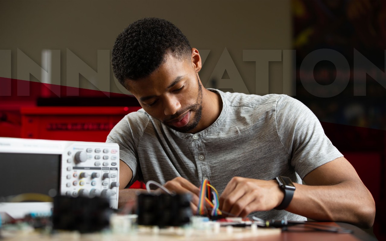 "A University of Cincinnati Engineering student works on an electrical board