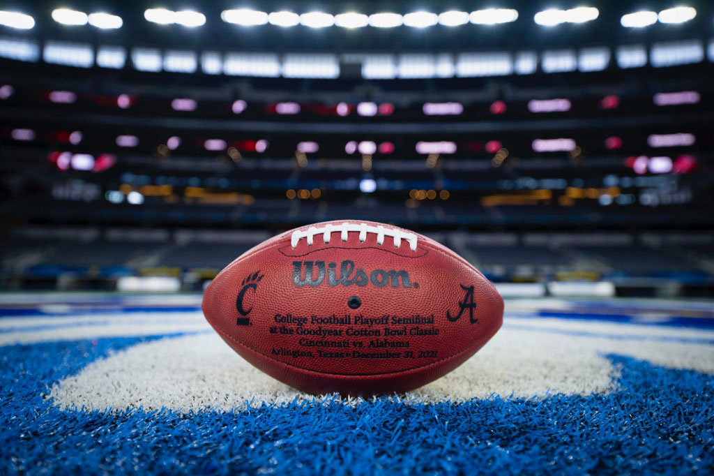A football lies on the sidelines of a football field