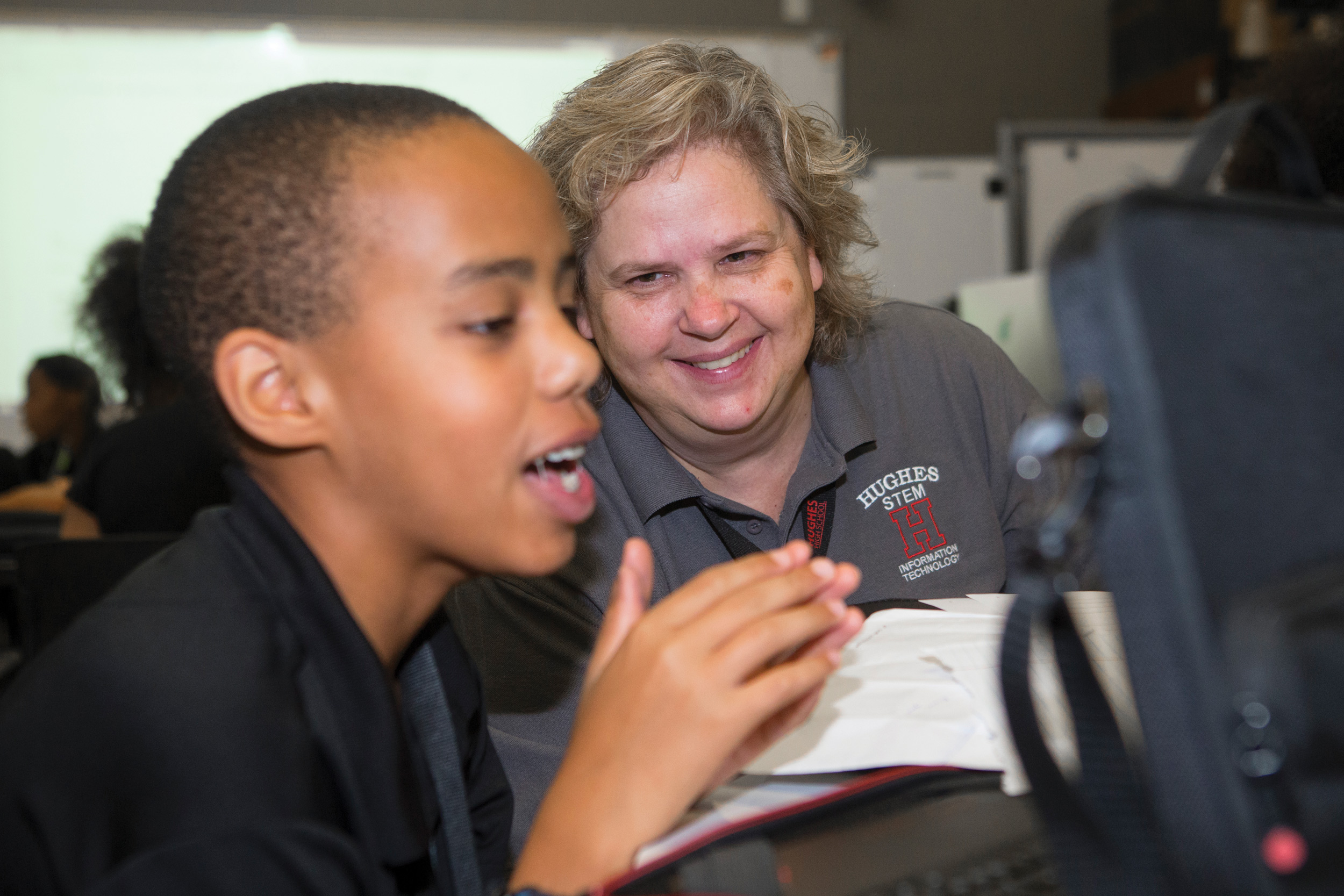 A mentor works with a young student on a STEM project