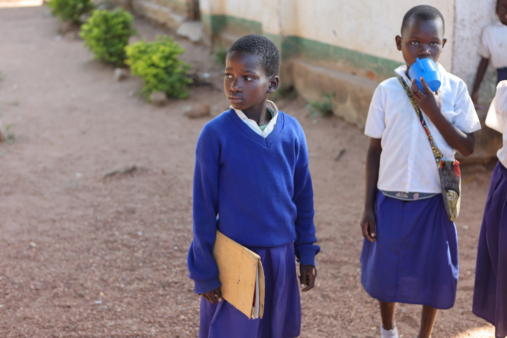 Two Tanzanian school children in blue uniforms
