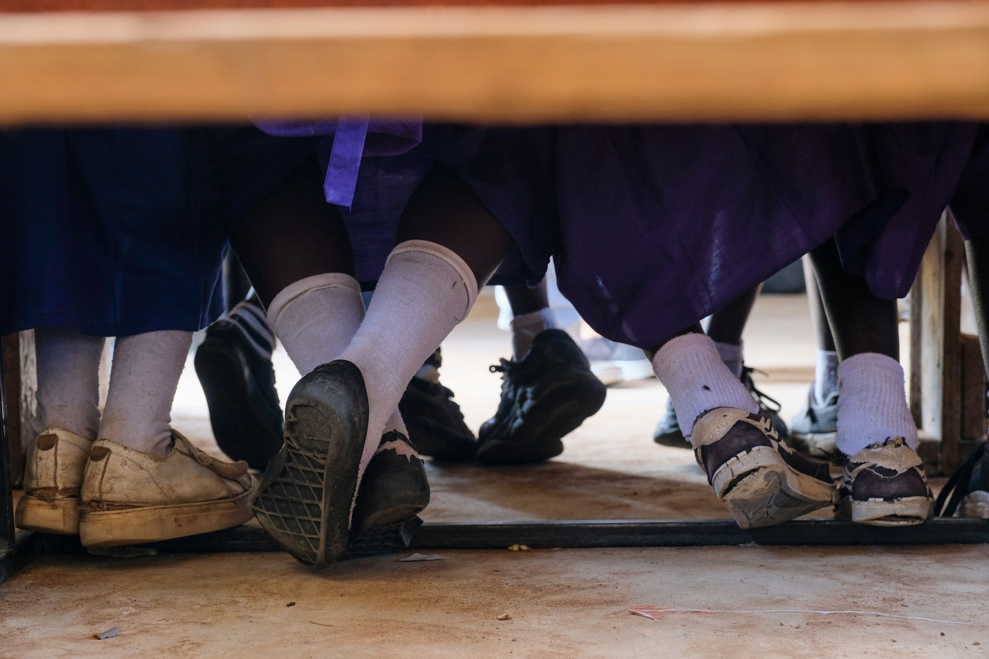View of the feet of Tanzanian children in school