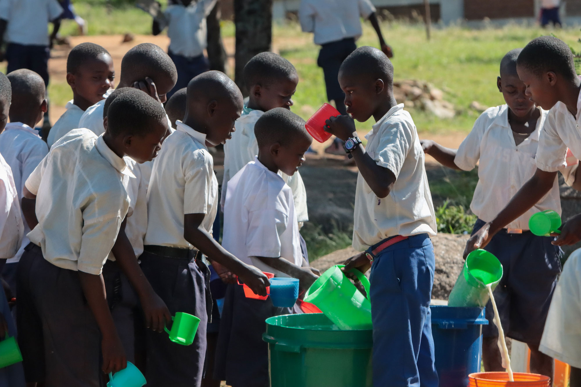 Tanzanian children line up for porridge