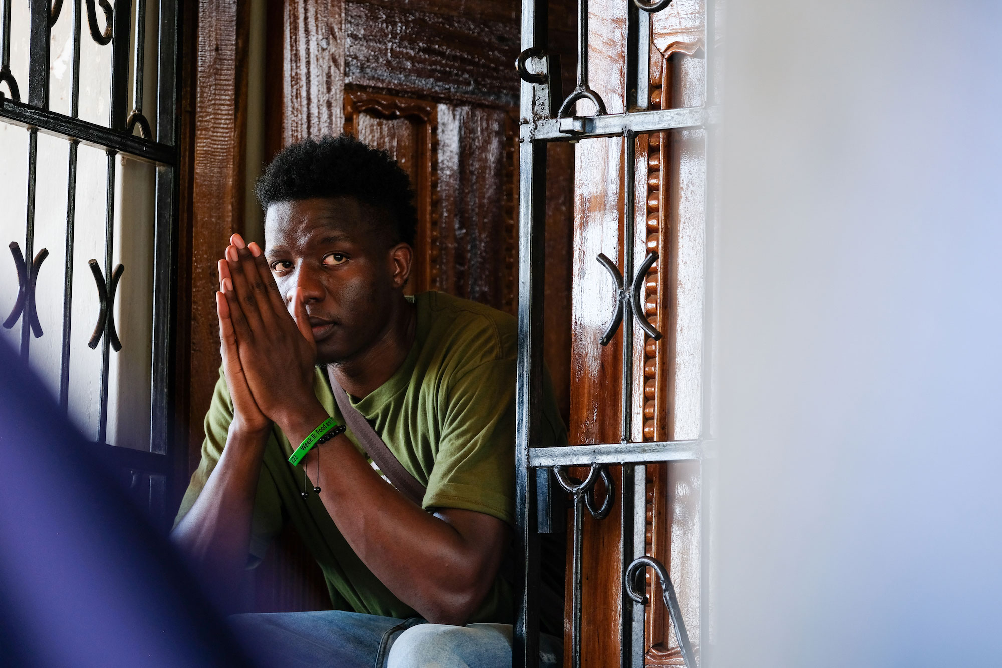 University of Cincinnati's Timoth Akama sits on a stoop with his hands folded