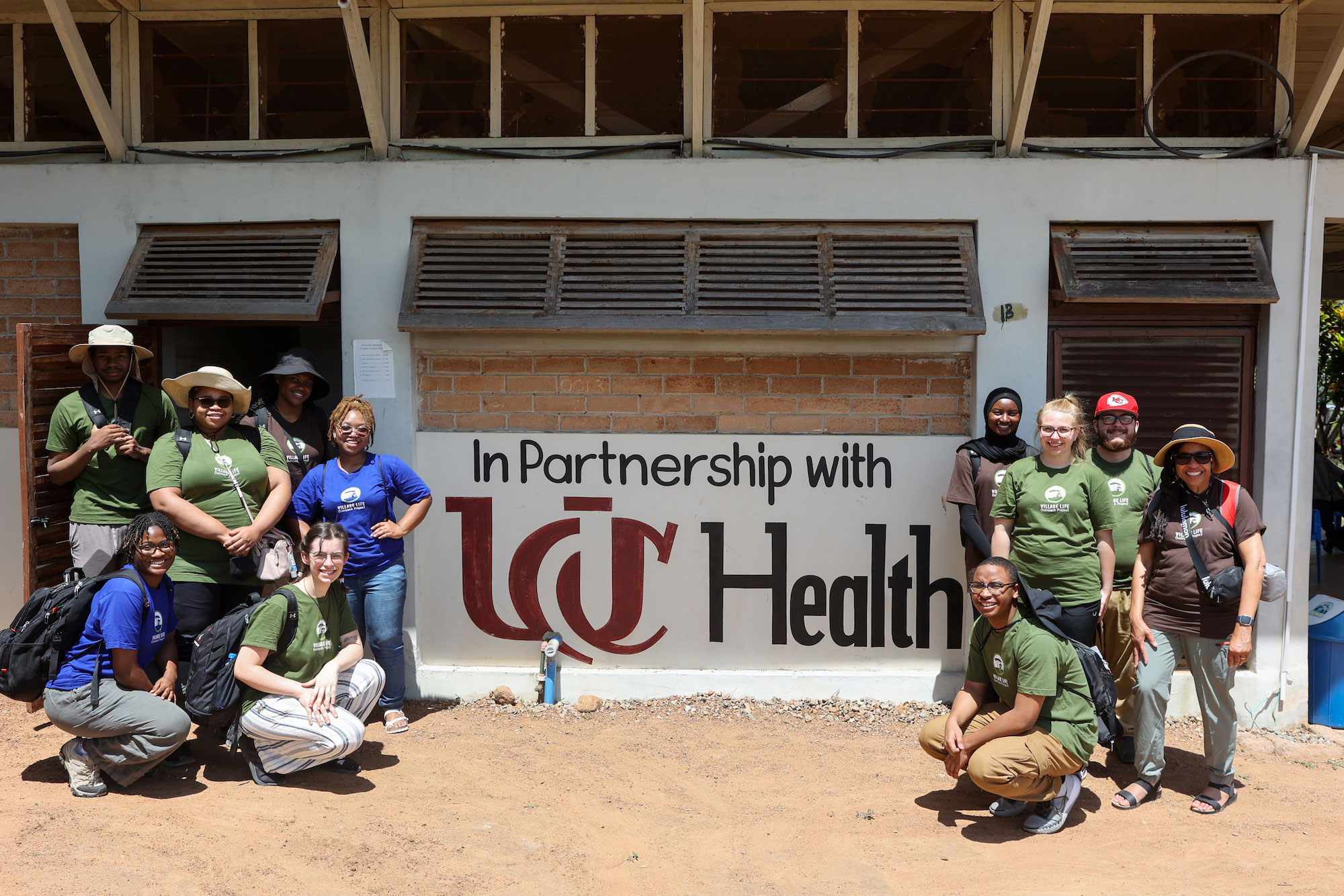 UC students pose with UC Health sign in Tanzania