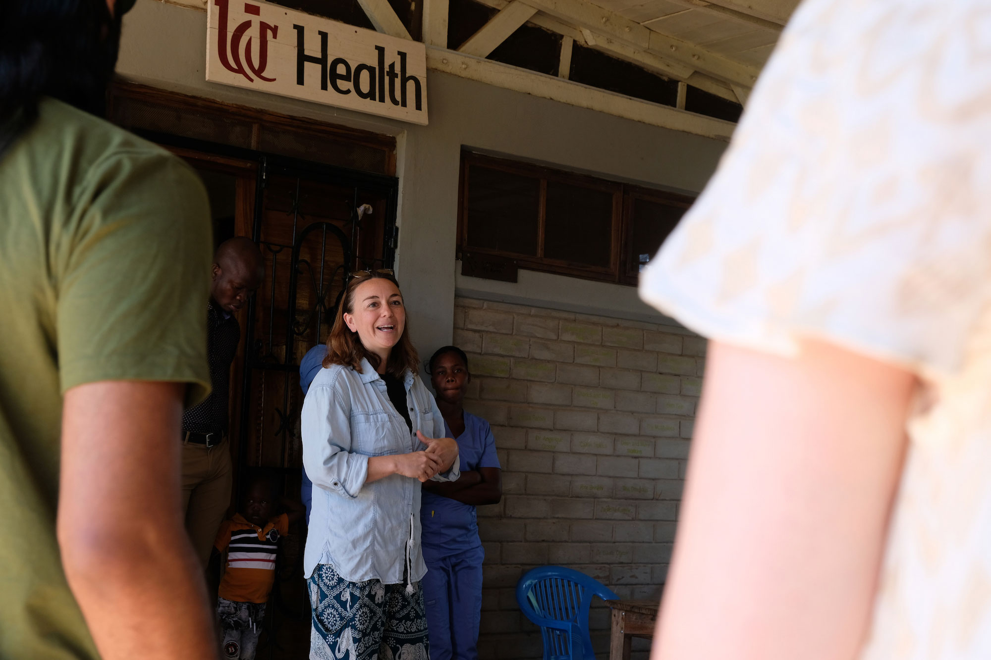 Woman speaks to group under UC Health sign