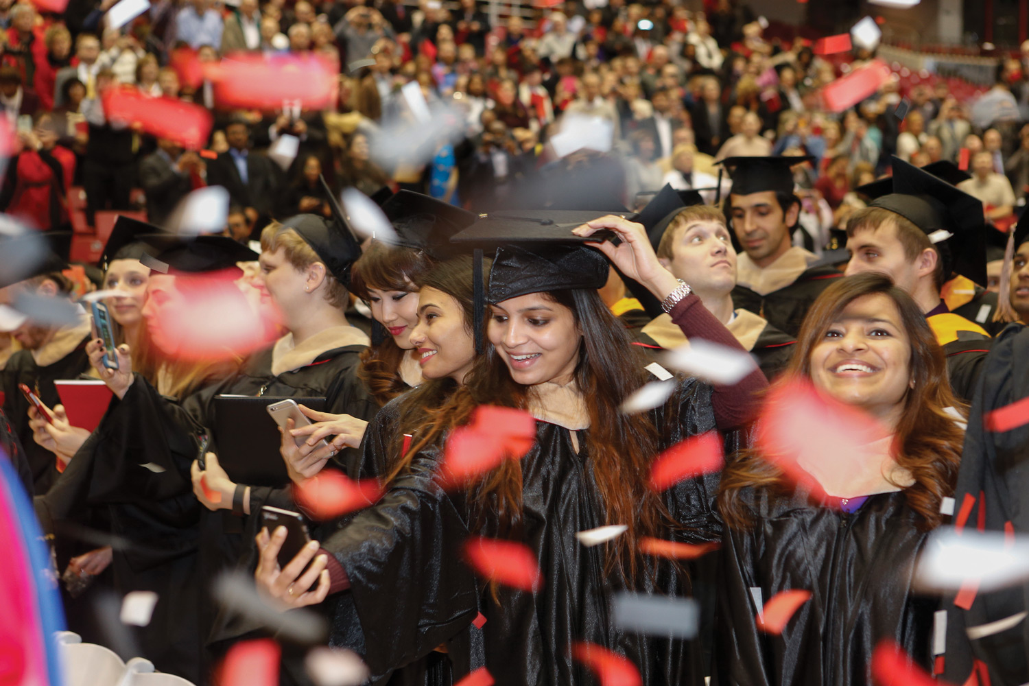 A student takes a selfie at hooding ceremony