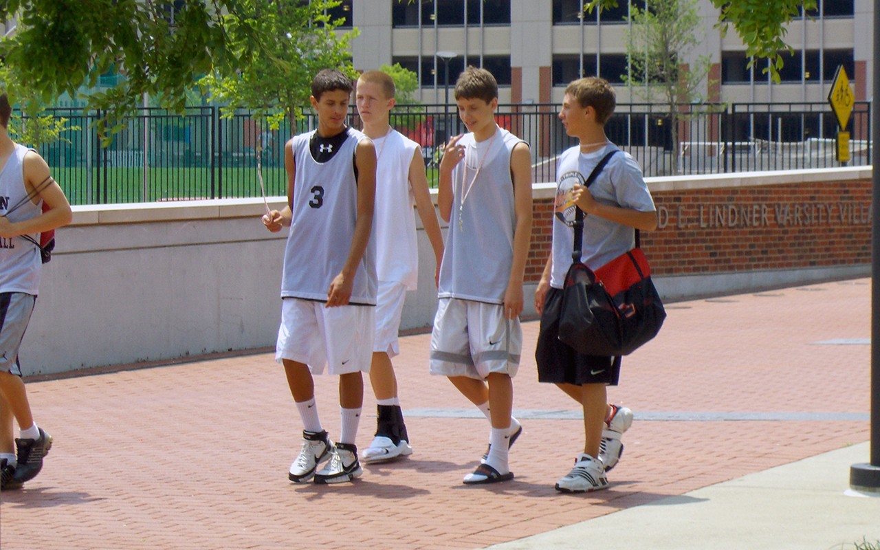 Male teens walking near athleic fields during sports camp
