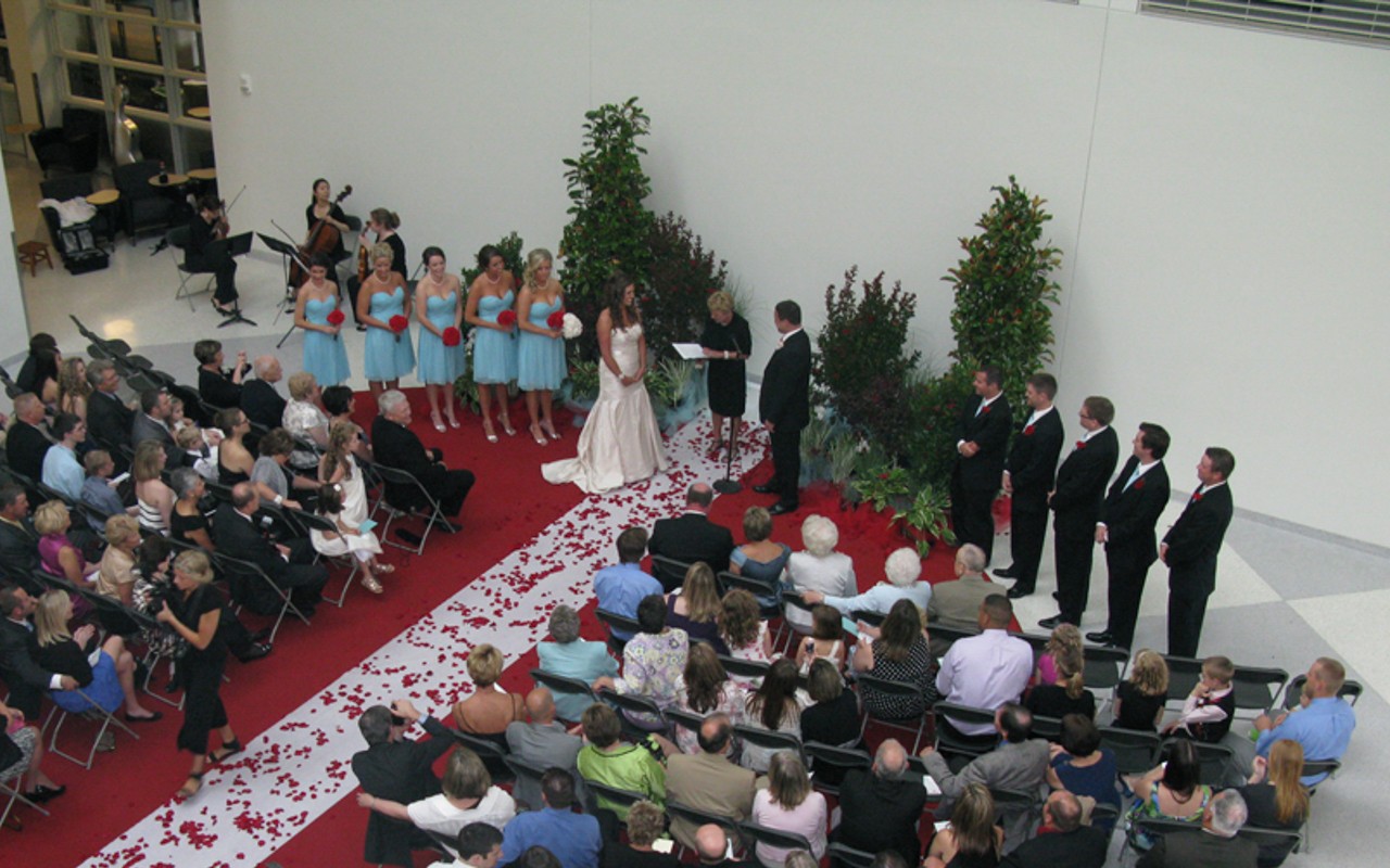 A wedding party and guests at ceremony in the Atrium of Tangeman University Center. 