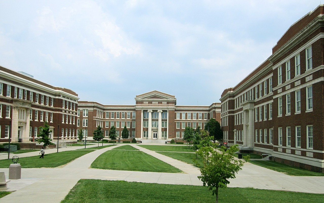 Open space between 3 buildings in a u-shape. There are green spaces and concrete walkways throughout