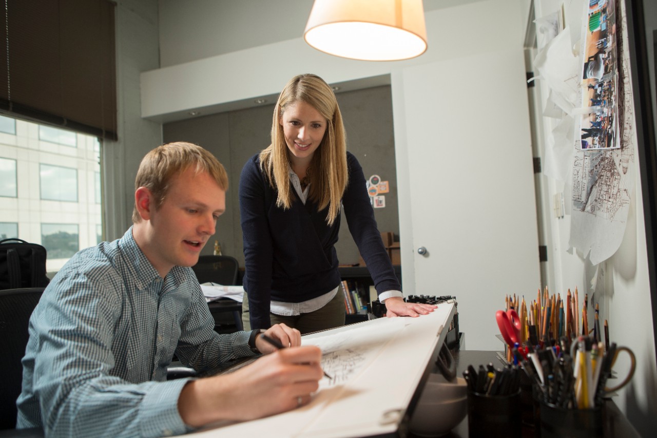 Two people working in office on design project