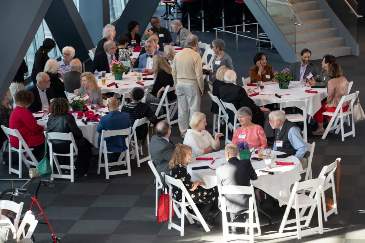 two tables of members from the Emeriti Association engaged in discussion