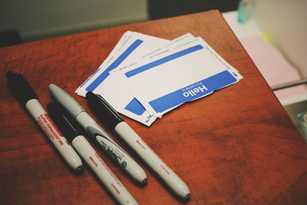 Name tags and Sharpies sit on a table.