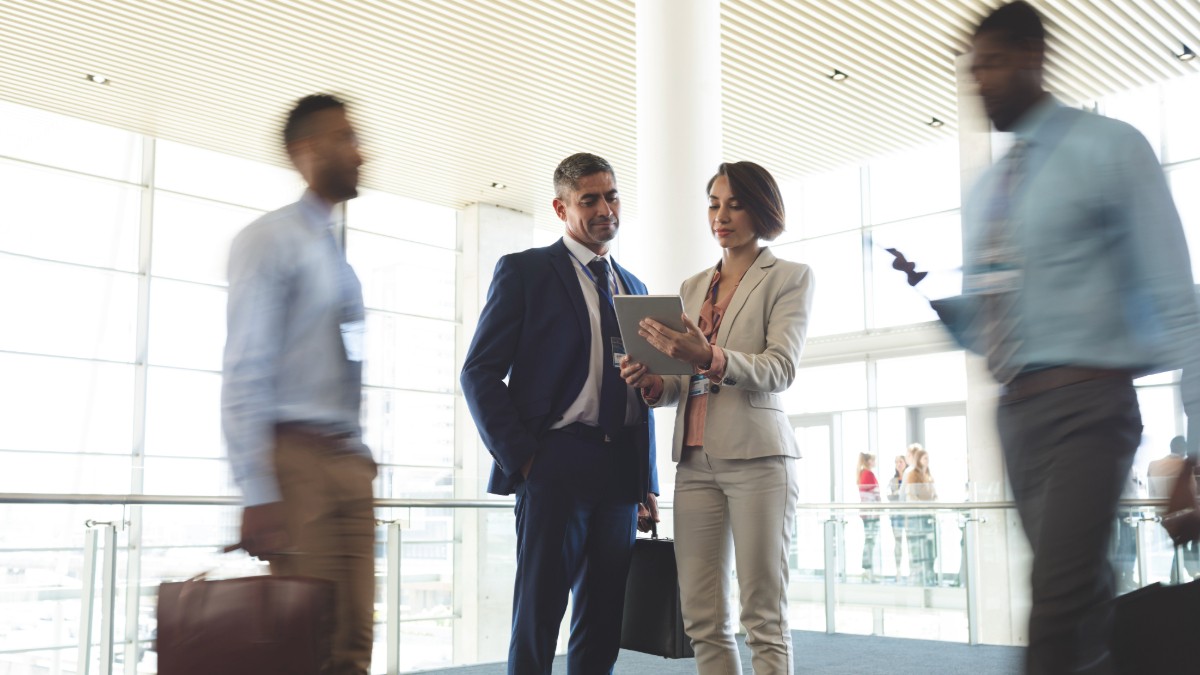 Business professionals networking as colleagues walk from meeting to meeting.