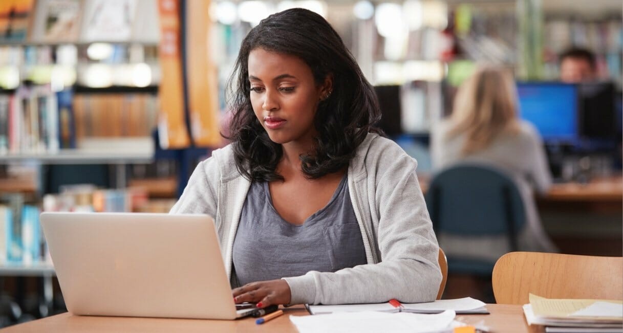 UC college student working on a laptop to create her LinkedIn profile