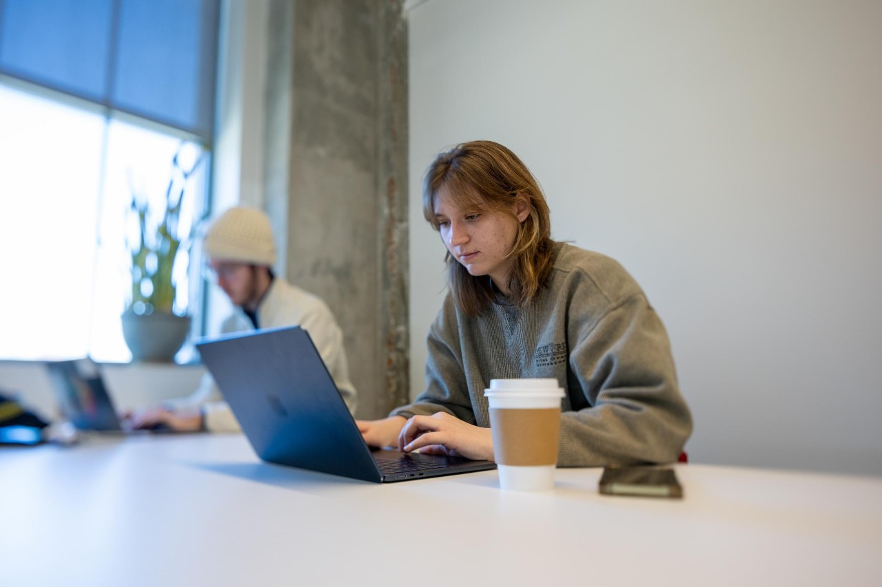 Gen Z students on laptops researching best financial tips for college students