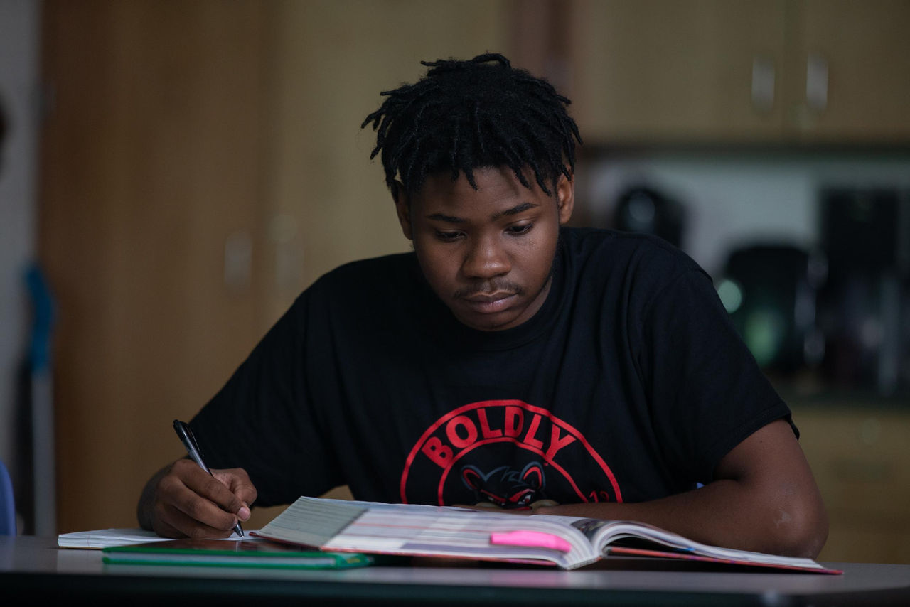 High school student at desk, preparing for college applications