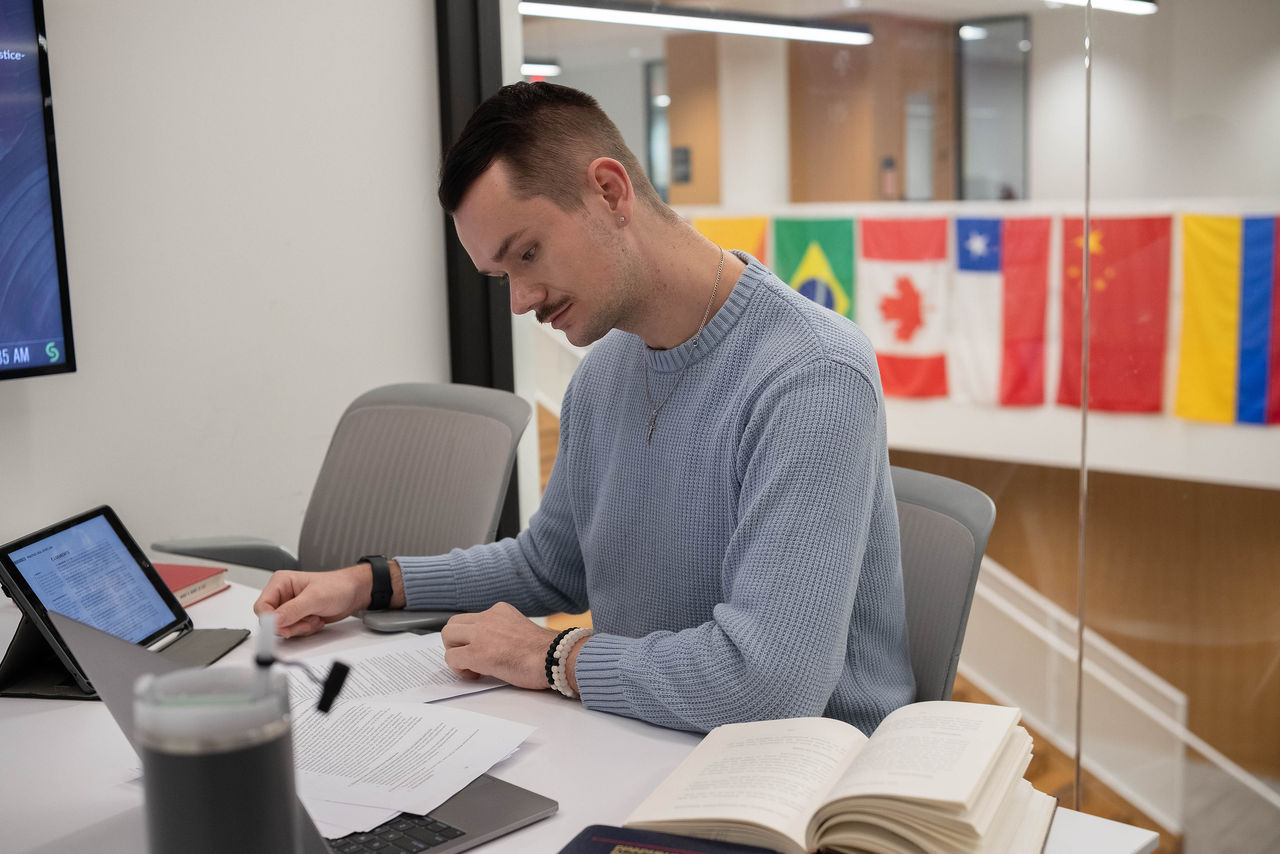 Young man in library considering which career path to choose