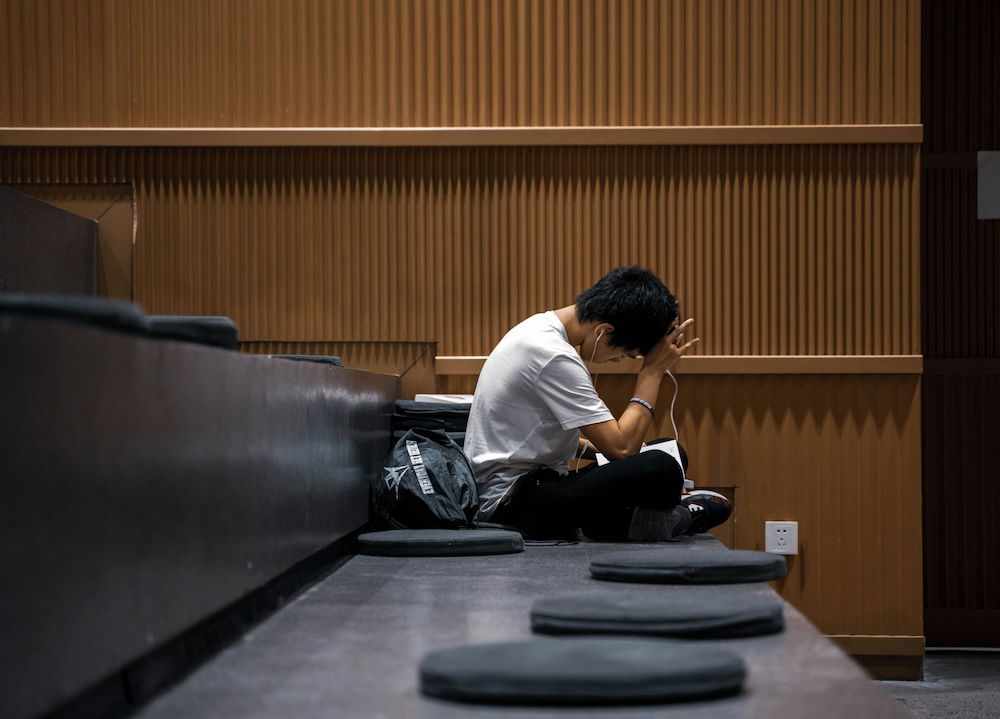 College student looking stressed out, sitting in a lecture hall