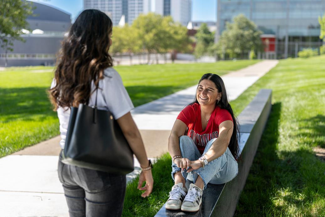 Two students talking on UC's campus green, a great way to make friends as an introvert