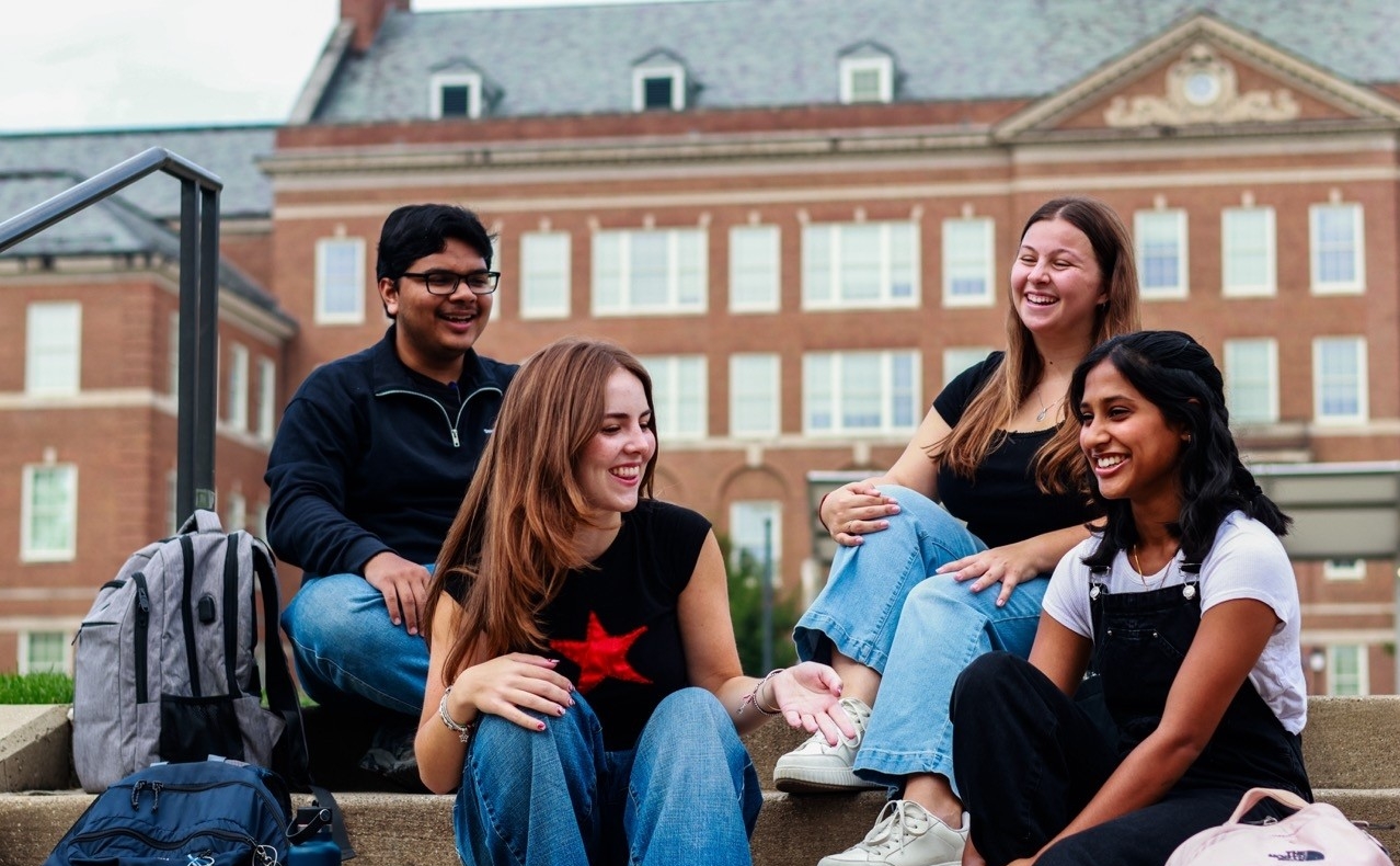 UC students sitting on stairs talking to eachother