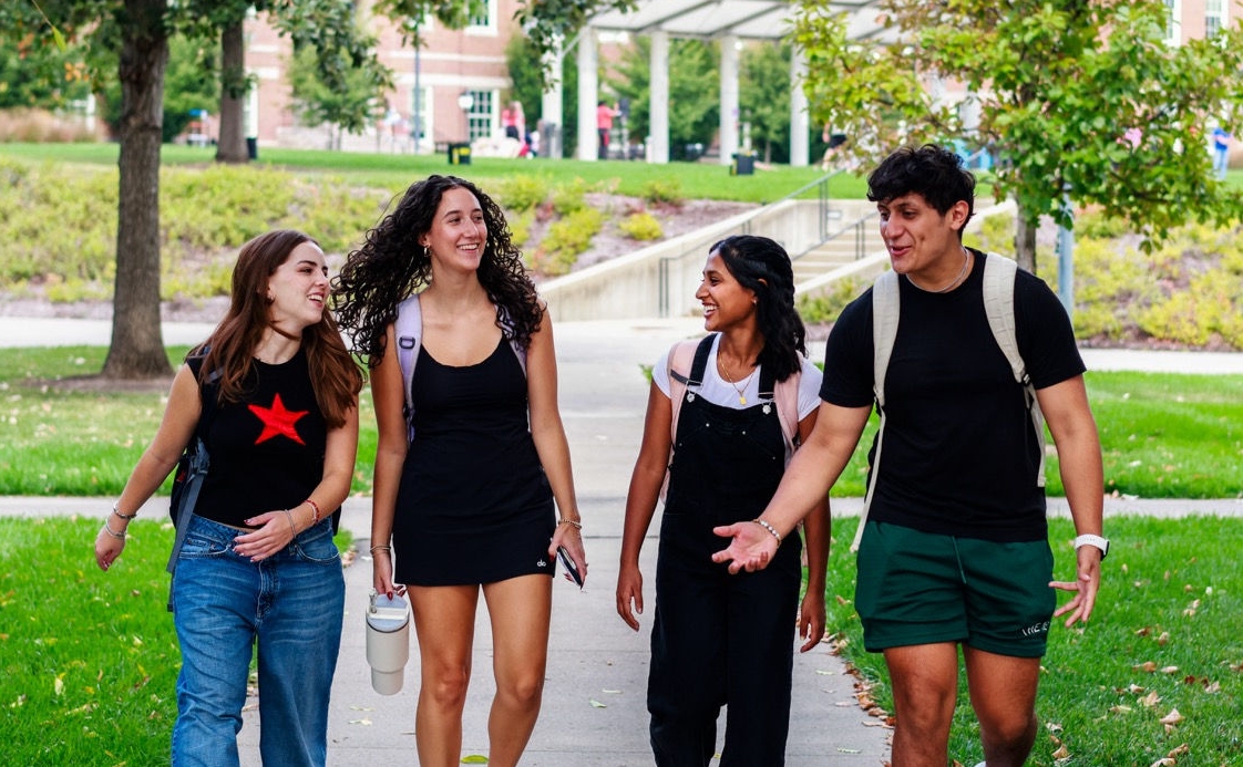 UC students talking and walking on campus together