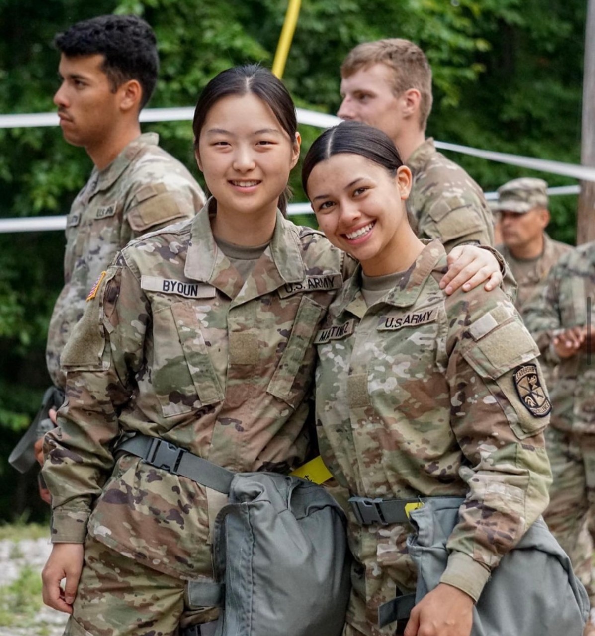 two female cadets posing together in fatigues