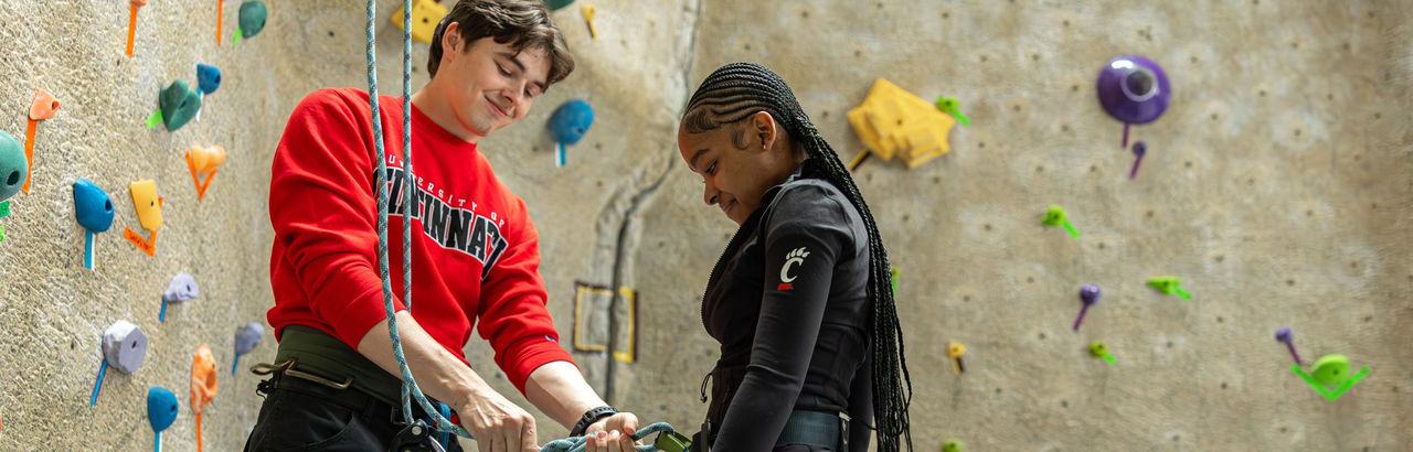 students at campus rec center climbing wall