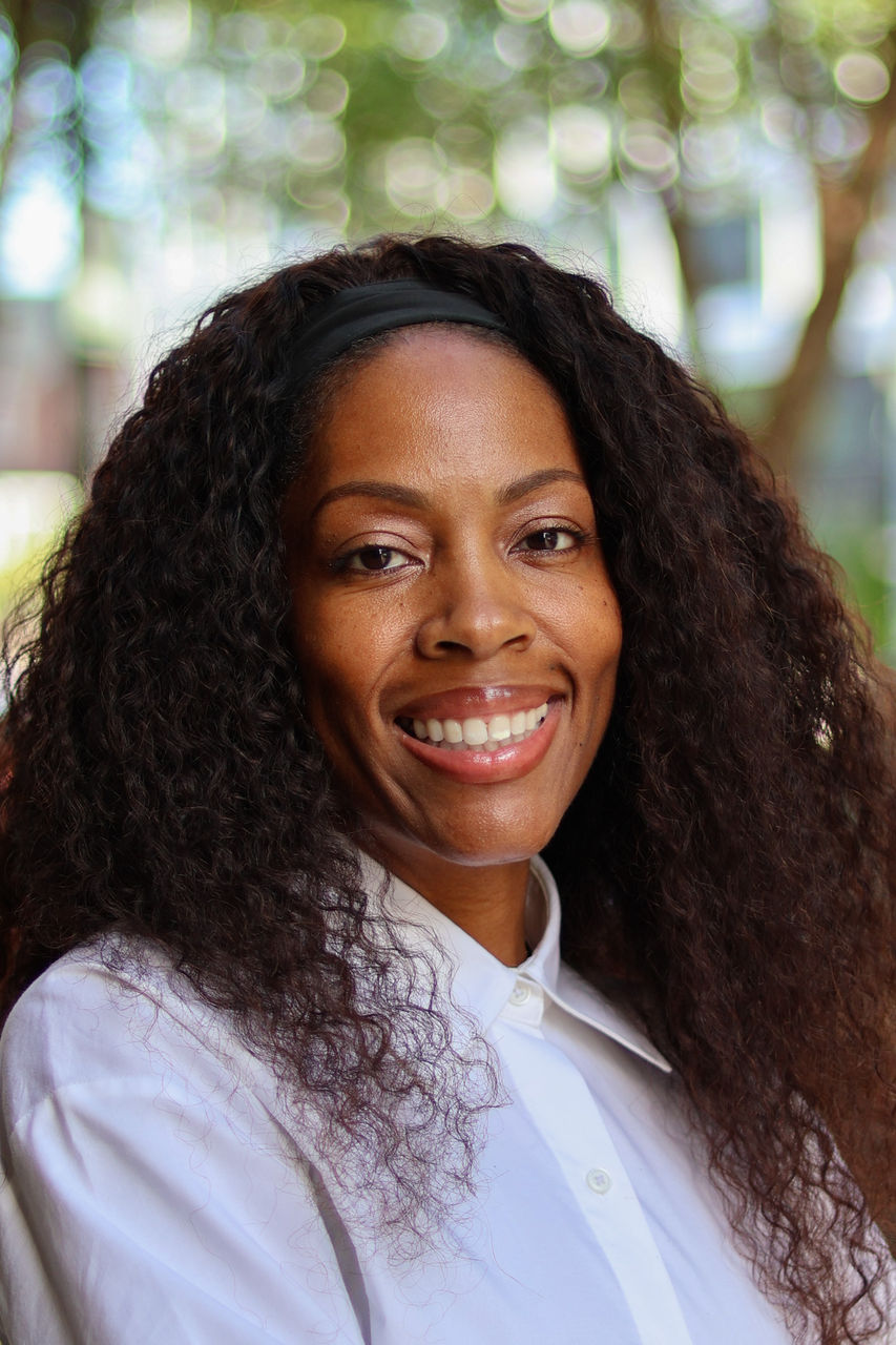 Photograph of Calisha smiling outside of CAPS building.