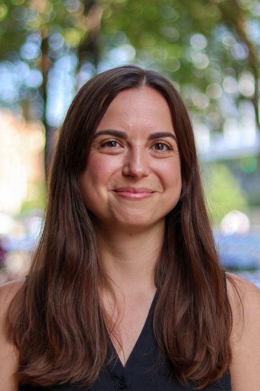 Photograph of Hannah smiling outside of CAPS building.