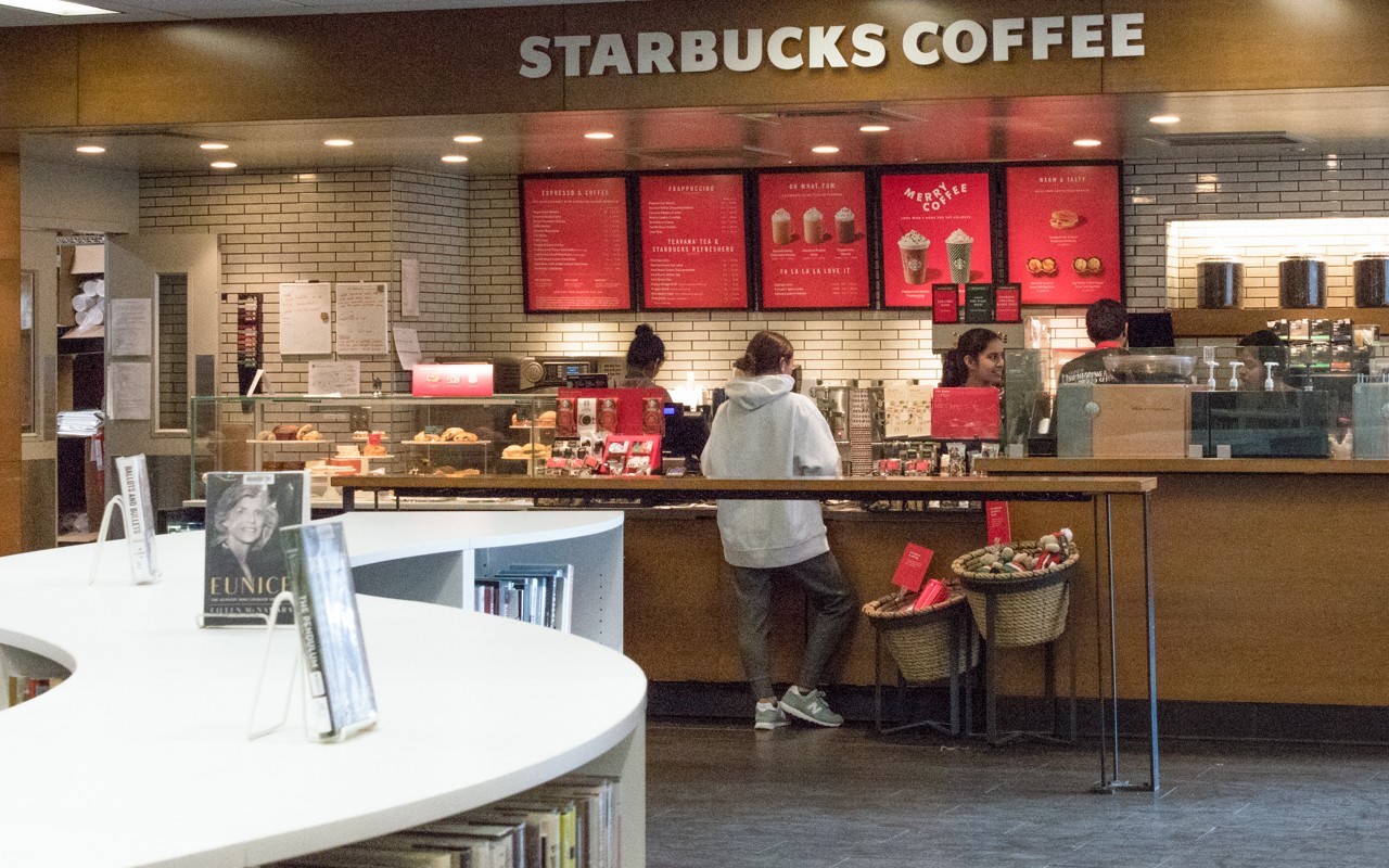 A student stands at the counter ordering items at the Langsam Library Starbucks.