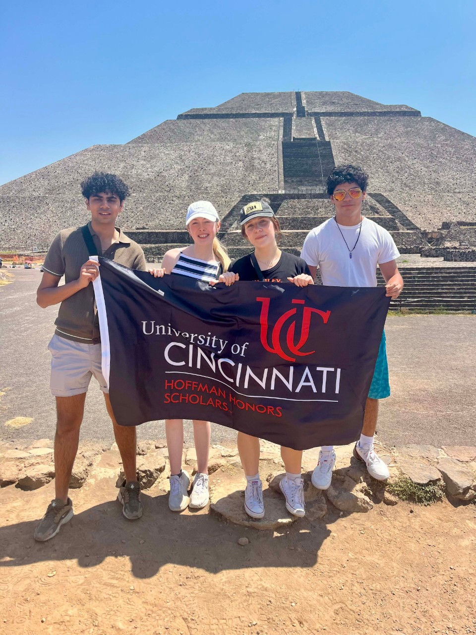 4 Hoffman Honors Scholars holding a Hoffman flag in Mexico on Study Abroad