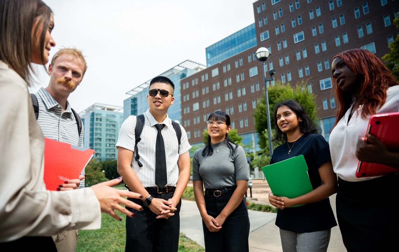 Students standing in a circle taking on campus