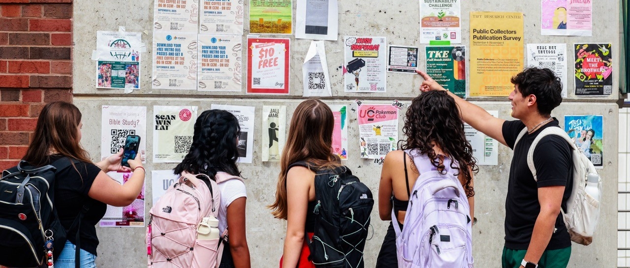 Students pointing and looking at a bulletin board