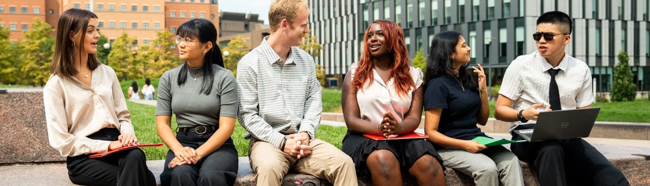 Students sitting in a row on campus