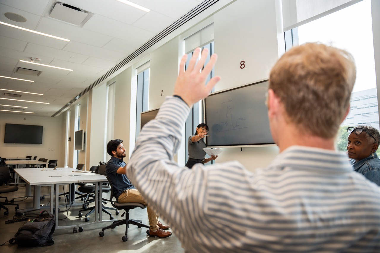 UHP student raising their hand in a classroom