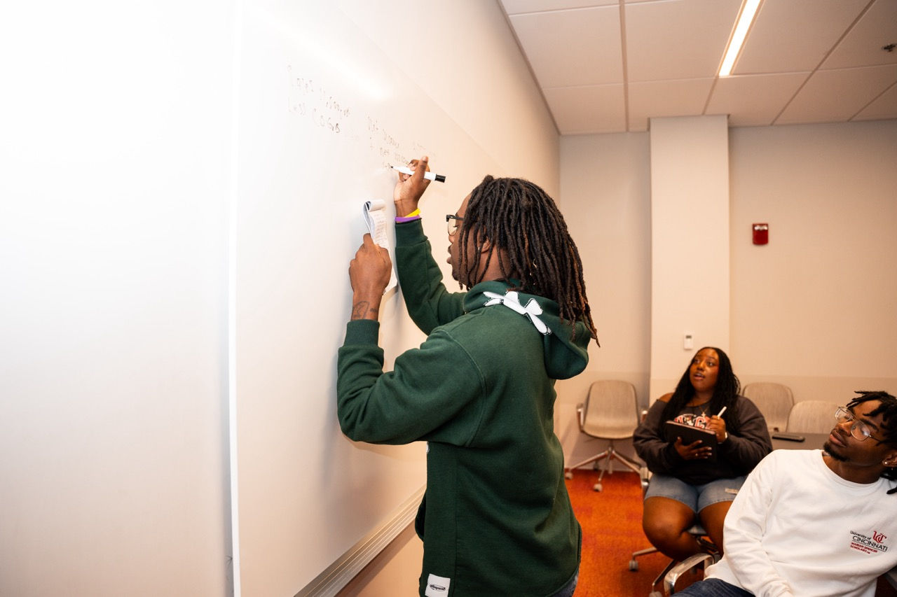 UHP student writing on a classroom whiteboard