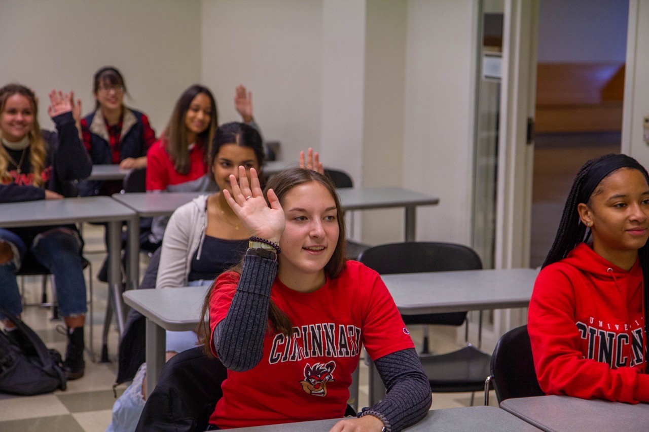 Female student raising hand in classroom