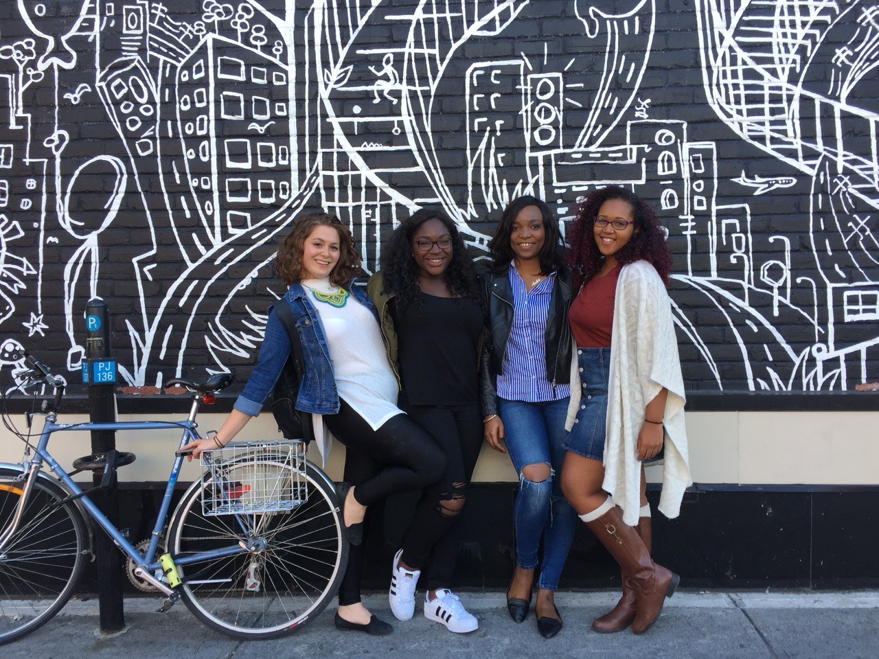 4 UHP students in front of a mural