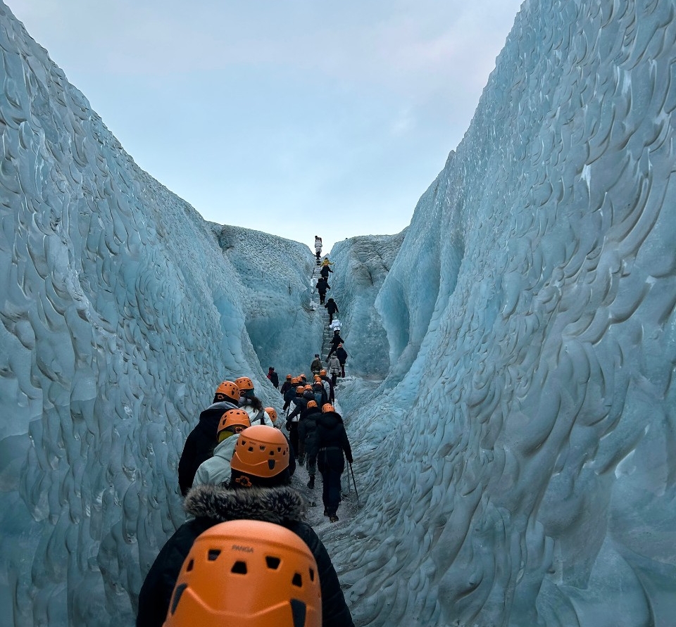 Three students smiling on black sand beach