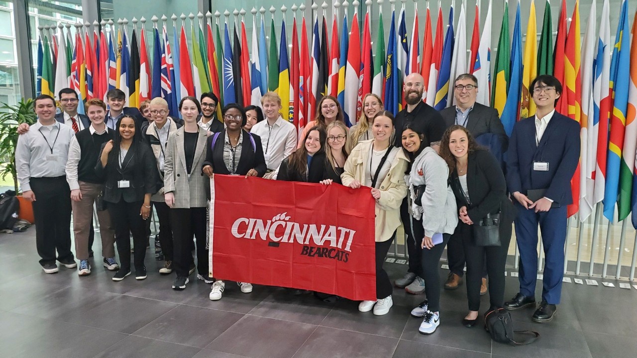 Students standing in front of world flags.