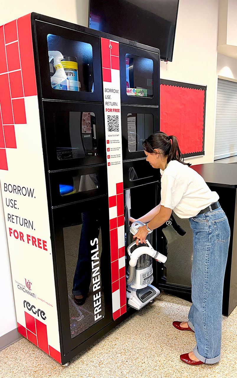 Female resident removing vacuum from locker