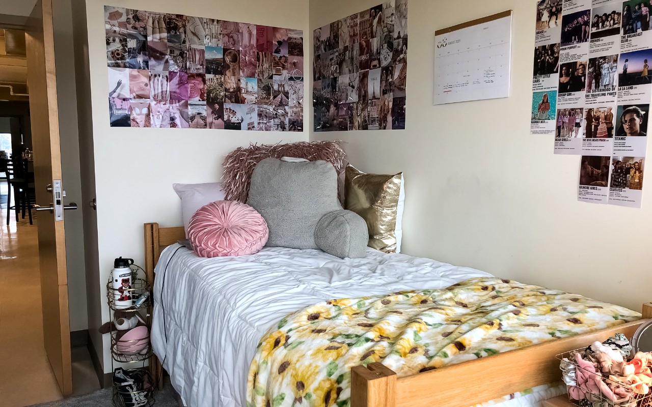 Twin bed rests along wall with decorations at the head of the bed. 
