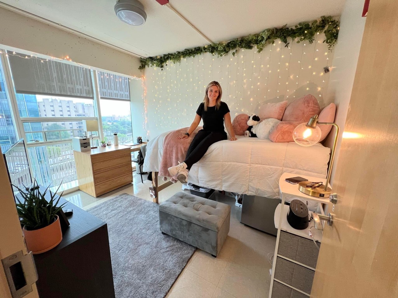 Bedroom in Scioto with pink grey and white decor and the student sitting on her bed